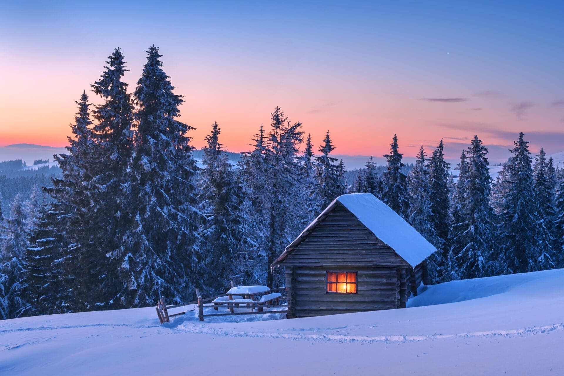 a small cottage on a mountain full of snow