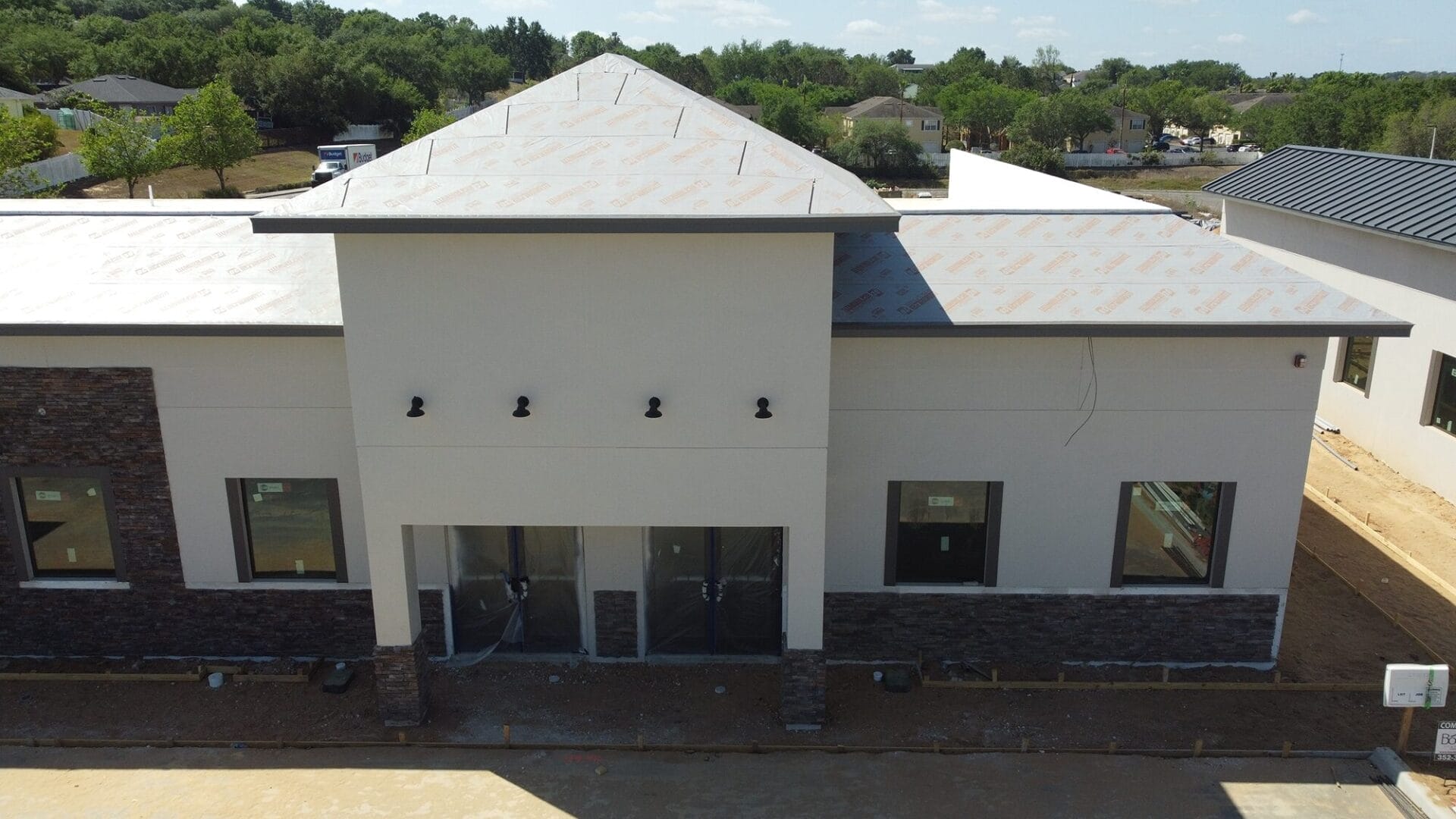 A commercial building under construction, featuring a triangular shaped roof