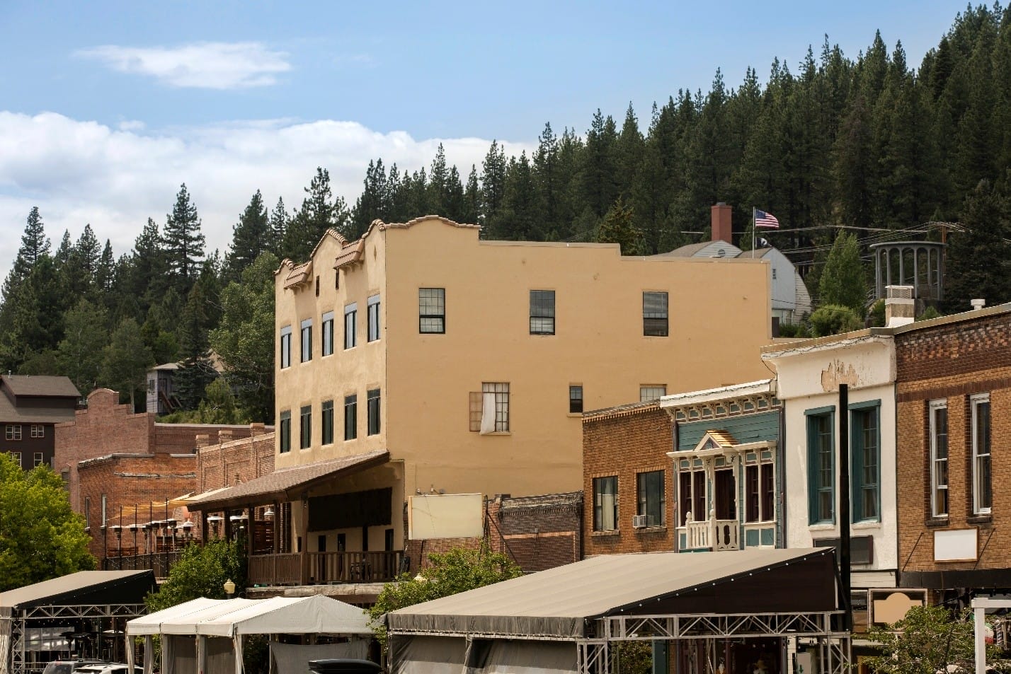 Historic downtown buildings in Placerville with tan and brick facades, covered by tents or awnings for commercial roof repair.